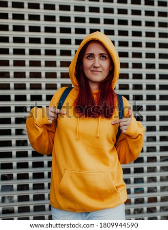 City portrait of handsome beautiful plus size girl wearing casual yellow blank hoodie or sweatshirt with space for your logo or design. Mock up for print