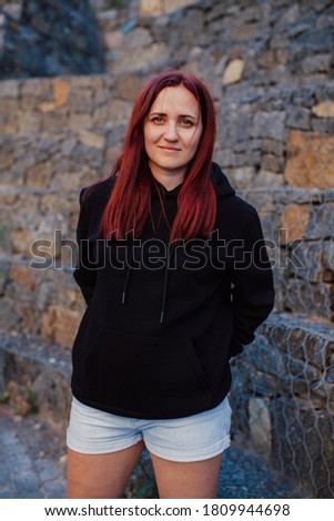City portrait of handsome beautiful plus size girl wearing casual black blank hoodie or sweatshirt with space for your logo or design. Mock up for print