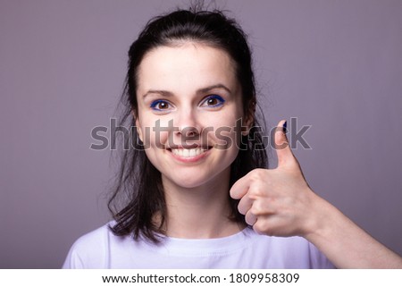 emotional woman in white t-shirt on gray studio background