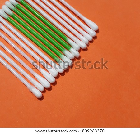 Cotton buds isolated on the orange background