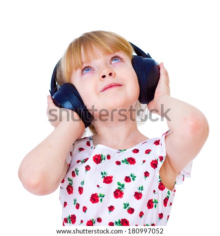 Very musical little girl having fun listening to music through the big, black headphones. isolated on white background