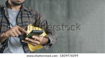 construction worker hands using smartphone on cement wall background with copy space Royalty-Free Stock Photo #1809976099