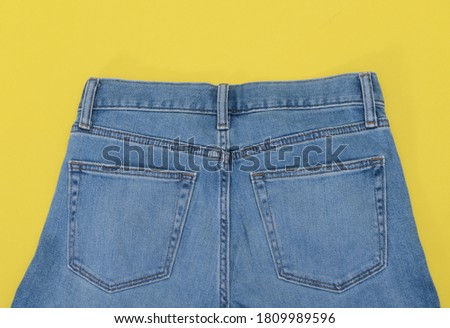 Border of blue jeans isolated on yellow background
