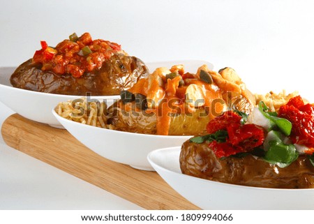 Three Stuffed Potatoes inside the white plate on the table