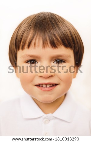 Portrait of caucasian child with smile. ID or passport photo little happy boy. Calm interesting kid in white shirt.