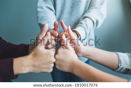 People making thumb up hands sign in circle