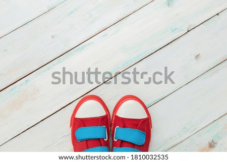 Red retro sneakers on a blue wooden background
