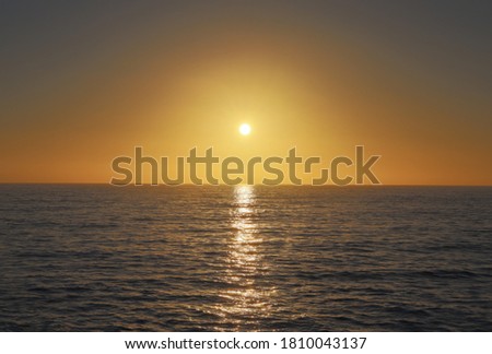 View of the sun setting over the ocean at Sunset Cliffs in California.