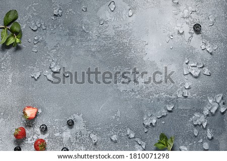 Crushed ice with strawberry and mint on vintage textures background. Top view with mint and berries. Blue background