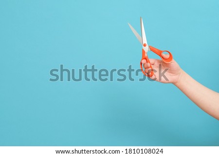 scissors in hands on blue background