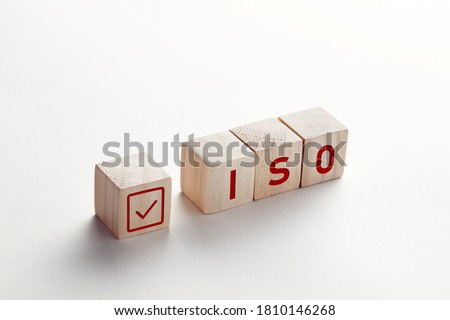 The abbreviation ISO on wooden cubes with check mark on white background. ISO quality control certification approval concept. Royalty-Free Stock Photo #1810146268
