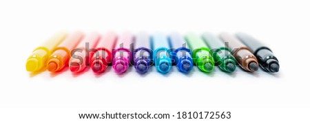 A set of multi-colored felt-tip pens in a row, rainbow on a light white banner background close-up. Drawing markers, pencils, ink, artist tools, creativity, leisure, hobby. Colorful school supplies. Royalty-Free Stock Photo #1810172563