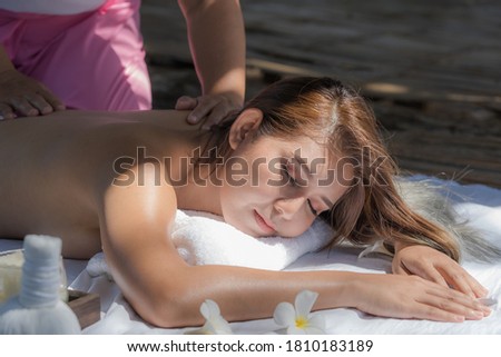 young woman enjoying massage in spa salon and good environment