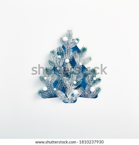 Christmas minimal concept - Xmas tree shape made of snowy fir branch. Square composition, flat lay, view from above. Winter spruce. Creative minimal.