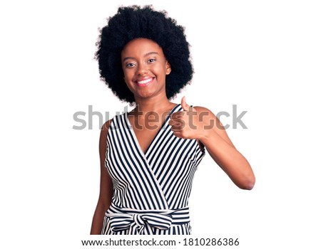 Young african american woman wearing casual clothes doing happy thumbs up gesture with hand. approving expression looking at the camera showing success. 