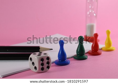 dice and gambling chips on a pink background