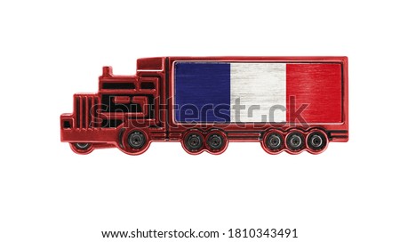 Toy truck with France flag shown isolated on white background. The concept of cargo transportation between countries.