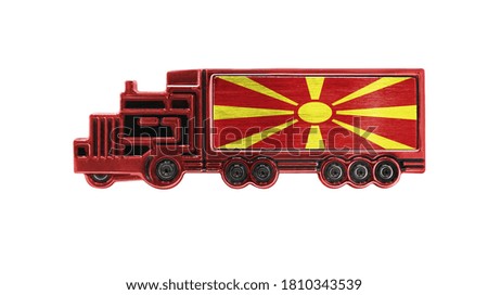 Toy truck with Macedonia flag shown isolated on white background. The concept of cargo transportation between countries.