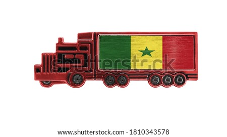 Toy truck with Senegal flag shown isolated on white background. The concept of cargo transportation between countries.