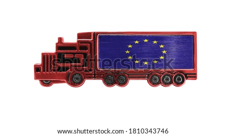 Toy truck with European Union flag shown isolated on white background. The concept of cargo transportation between countries.
