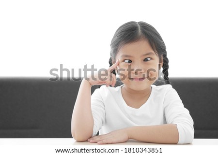 Asian child strabismus or kid girl squint lazy eye and amblyopia think with finger point brain head for new idea and imagination or creativity education with smile happy at nursery pre school on white Royalty-Free Stock Photo #1810343851