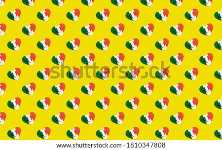 seamless pattern two wooden hearts small lies on large painted in colors of flag of Italy green, white and red on yellow background