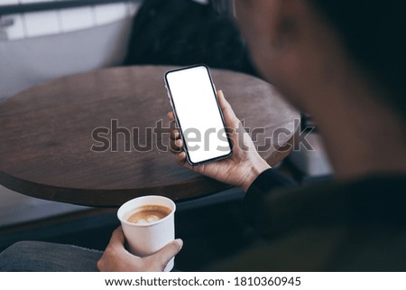 cell phone mockup blank white screen.woman hand holding texting using mobile on desk at coffee shop.background empty space for advertise.work people contact marketing business,technology 