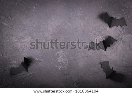 Black marble surface with paper bats. creepy holiday background with space for text