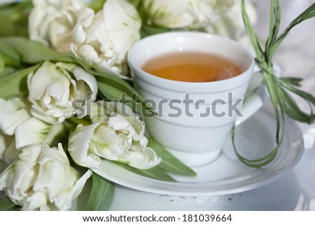 Cup of tea with spring flowers in a sunlight