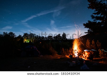 Camping fire on mountain with young people