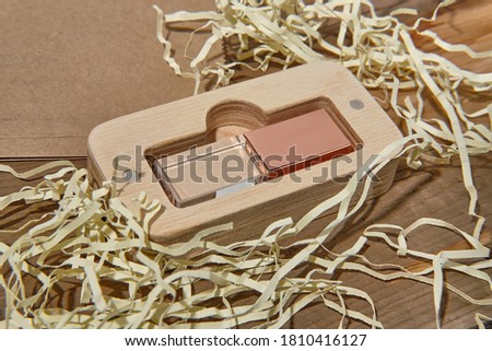 Flash drive glass and metal. Nicely decorated USB stick on a wooden background. The top is covered with a glass cover.