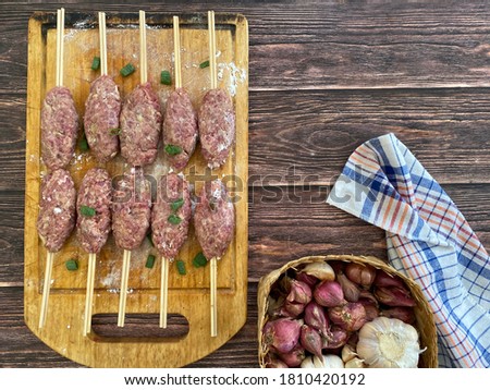 Flat lay of Raw Beef satay is ready to grill. It is an Indonesian cuisine, in Solo, Centre Java, they called Sate Buntel. It is made from minced beef or lamb  with spices and herbs. Copy space.