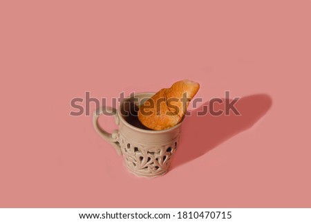 Modern image of classic breakfast with cup of coffee and croissant on pastel pink background