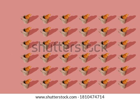 Modern image pattern of classic breakfast with cup of coffee and croissant on pastel pink background