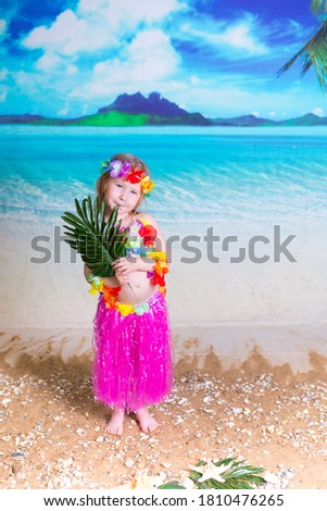 little girl in a Hawaiian costume on the ocean