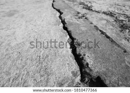 A large crack in concrete. Earthquake concept photo. This picture has selective focus. 