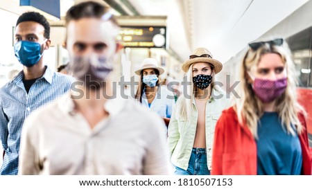 Friends group walking at railway station - New normal travel concept with young people covered by protective mask - Focus on blond girl with hat Royalty-Free Stock Photo #1810507153