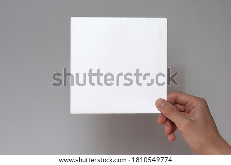 Hands hold a  sheet. Empty space for the label.