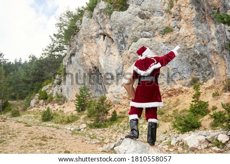 santa claus pointing to a mountain to climb