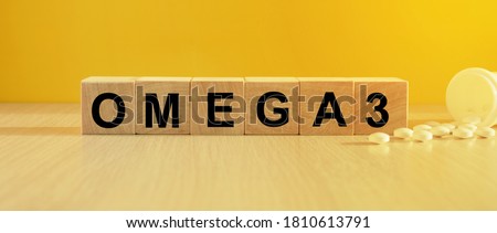 The inscription omega3 on wooden cubes, bright yellow background. Health and medicine concept. Royalty-Free Stock Photo #1810613791