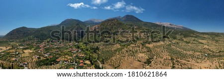 Aerial drone panoramic photo of medieval byzantine old city of Mystras featuring Monastery of Pantanassa, Temple of Agia Sofia and uphill castle of Mystras, Sparta, Peloponnese, Greece