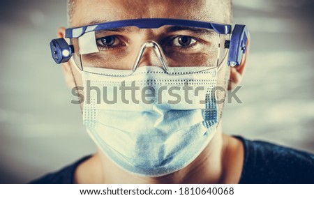 Medic wearing goggles and a surgical mask. Protection against coronavirus. Portrait of a diagnostician doctor close-up. Medic ready for a second wave of coronavirus.