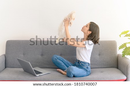 Beautiful young asian woman working on sofa at home with her maltese dog, Cheerful and nice couple with people and pet