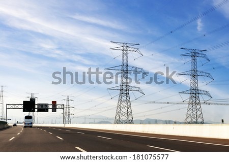 high voltage post.High-voltage tower sky background,besides the highway.
