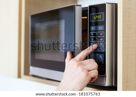 Detail of male hand while using the microwave Royalty-Free Stock Photo #181075763