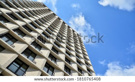 Exterior of a modern multi-story apartment building - facade, windows and balconies. Royalty-Free Stock Photo #1810765408