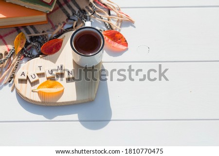 Coffee mug and wooden letters on a wooden stand in the shape of a heart on a white table. The concept of the fall season. A Cup of tea with autumn leaves. fall time. Copy space.