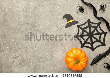 Halloween composition with spiders and bats on grey concrete background. Top view