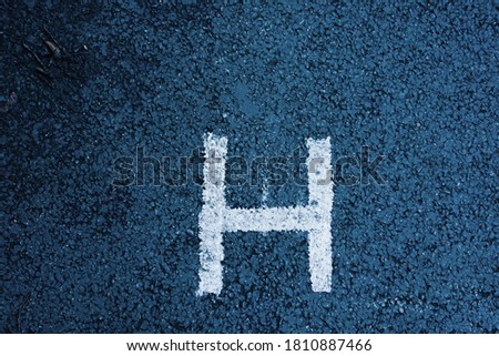 letter H painted on tarmac of a parking bay