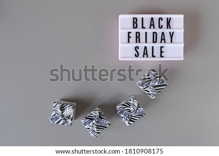 Black Friday sale text on white lightbox and gift boxes on gray background. Black Friday sign with copy space. Thanksgiving promotion advertising